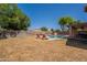 Backyard pool and lounge chairs are surrounded by green trees and a private block fence at 1125 S Larkspur St, Gilbert, AZ 85296