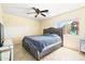 Bedroom with plush bed, ceiling fan, and window view of backyard playset at 11921 W Flores Dr, El Mirage, AZ 85335