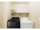 Laundry room with modern black washing machine and white dryer at 11921 W Flores Dr, El Mirage, AZ 85335
