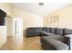A spacious living room with tile flooring and an over-sized gray sectional at 11921 W Flores Dr, El Mirage, AZ 85335