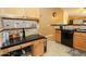 Features a black dishwasher with oak cabinets and black countertop area with space for snacks and drink storage at 1210 W Betty Elyse Ln, Phoenix, AZ 85023