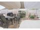 Inviting patio area with a table and chairs, plus a shade covering and some landscaping at 1210 W Betty Elyse Ln, Phoenix, AZ 85023