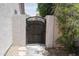 Wrought iron gate nestled between stucco walls, leading to a private outdoor space at 1210 W Betty Elyse Ln, Phoenix, AZ 85023