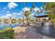 Stunning lakefront backyard featuring a built-in kitchen, fire features, and lush landscaping at 1241 W Lobster Trap Dr, Gilbert, AZ 85233