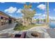 Lush backyard featuring a patio with an outdoor kitchen, pergola, fire pit and water views at 1241 W Lobster Trap Dr, Gilbert, AZ 85233