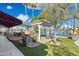 Inviting backyard with lake views, fire features, pergola, outdoor kitchen, and lush landscaping at 1241 W Lobster Trap Dr, Gilbert, AZ 85233