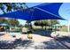 Community playground with a large blue sunshade and picnic tables for Gathering fun at 1241 W Lobster Trap Dr, Gilbert, AZ 85233