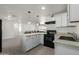 Modern kitchen with white cabinets, stone countertops, sleek appliances, and an open layout at 1408 E Orange St, Tempe, AZ 85281