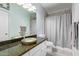 Bathroom featuring vanity with granite countertop, vessel sink, and shower/tub combination with gray shower curtain at 1442 W Laurel Ave, Gilbert, AZ 85233