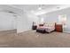 Spacious main bedroom with neutral tones, carpet flooring, a ceiling fan, and ample natural light from the windows at 1442 W Laurel Ave, Gilbert, AZ 85233
