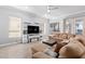 Comfortable living room featuring a large sectional sofa, a ceiling fan, multiple windows and modern entertainment center at 1442 W Laurel Ave, Gilbert, AZ 85233