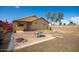 This backyard features a brick patio set with a black table and chairs and lush, colorful landscaping at 15805 W Morning Glory St, Goodyear, AZ 85338