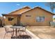 This backyard features a brick patio set with a table and chairs, a desert landscape, and a covered outdoor area at 15805 W Morning Glory St, Goodyear, AZ 85338