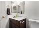 Bathroom featuring modern vanity with white countertop, dark wood cabinets, a large mirror, and stylish fixtures at 15805 W Morning Glory St, Goodyear, AZ 85338