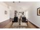 Open living room with hardwood floors, vaulted ceilings, contemporary furniture and a glimpse into the dining area at 15805 W Morning Glory St, Goodyear, AZ 85338