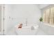 Bright bathroom featuring a modern soaking tub with marble backsplash and shuttered window at 16219 S 14Th Way, Phoenix, AZ 85048