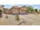 Tan home featuring a long driveway, three car garage and sparse desert landscaping in the front yard at 16219 S 14Th Way, Phoenix, AZ 85048
