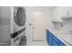 Laundry room with stacked washer and dryer and blue and white cabinets at 16219 S 14Th Way, Phoenix, AZ 85048
