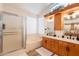 Well-lit bathroom featuring a large soaking tub, glass-enclosed shower, and double vanity with wood cabinets at 1635 E Harrison St, Chandler, AZ 85225