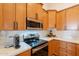 Well-lit kitchen featuring stainless steel appliances, warm wood cabinetry, and a white subway tile backsplash at 1635 E Harrison St, Chandler, AZ 85225