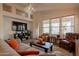 Relaxing living room featuring a cozy seating arrangement, a large TV, and natural light from windows at 1635 E Harrison St, Chandler, AZ 85225