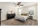 Neutral bedroom featuring a metal bed frame, two windows, a ceiling fan, and carpeted floors at 19951 W Wilson St, Buckeye, AZ 85326