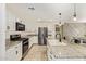 Updated kitchen with white cabinets, stainless steel appliances, granite countertops, and a large island at 19951 W Wilson St, Buckeye, AZ 85326