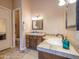 Well-lit bathroom with custom wood cabinets, granite counters, and elegant fixtures at 20439 E Palomino Dr, Queen Creek, AZ 85142