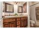 Well-lit bathroom with granite-topped double vanity and matching cabinets and tub/shower at 20439 E Palomino Dr, Queen Creek, AZ 85142
