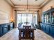 Dining room with a large dining table, travertine floors, and two dark wood cabinets at 20439 E Palomino Dr, Queen Creek, AZ 85142