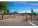 Equestrian access point with a wooden fence, a sign indicating access, and desert surroundings with a clear blue sky at 20439 E Palomino Dr, Queen Creek, AZ 85142