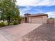 Well-maintained single-story home with stone tower, a large driveway, and mature landscaping at 20439 E Palomino Dr, Queen Creek, AZ 85142