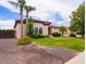 Beautifully landscaped front yard with lush green grass, mature trees, and colorful flowerbeds at 20439 E Palomino Dr, Queen Creek, AZ 85142