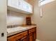 Spacious laundry room with a utility sink, wooden cabinets, and tile floors at 20439 E Palomino Dr, Queen Creek, AZ 85142