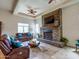 Living room showcasing a stone fireplace, leather sofas, and tray ceiling at 20439 E Palomino Dr, Queen Creek, AZ 85142