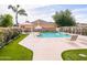 Beautiful pool area with lounge chairs, manicured landscaping, and shade, ideal for summer relaxation at 20439 E Palomino Dr, Queen Creek, AZ 85142