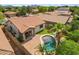 Aerial view of backyard with a covered patio, beautiful pool, lush landscaping, and mountain views at 21362 E Puesta Del Sol Rd, Queen Creek, AZ 85142