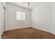 A basic bedroom with neutral walls, brown carpet, a ceiling fan, and a window with blinds at 21362 E Puesta Del Sol Rd, Queen Creek, AZ 85142