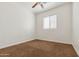 A basic bedroom with neutral walls, brown carpet, a ceiling fan, and a window with blinds at 21362 E Puesta Del Sol Rd, Queen Creek, AZ 85142