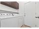 A functional laundry room featuring a white washer and dryer, and ample cabinet space at 21362 E Puesta Del Sol Rd, Queen Creek, AZ 85142