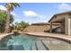Backyard swimming pool with a rock waterfall feature and a spacious patio, perfect for outdoor relaxation at 21362 E Puesta Del Sol Rd, Queen Creek, AZ 85142