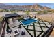 Inviting backyard pool, spa, and kitchen create a relaxing oasis with travertine tile and mountain views at 21632 W Hillcrest Blvd, Buckeye, AZ 85396