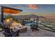 Inviting backyard with a modern pool, spa, outdoor kitchen, fire pit, and mountain views at 21632 W Hillcrest Blvd, Buckeye, AZ 85396