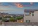 Backyard view showcasing privacy wall, mature landscaping, and distant city lights at 21632 W Hillcrest Blvd, Buckeye, AZ 85396
