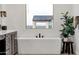 Inviting bathroom featuring a modern soaking tub, a stylish wooden stool, and mountain views at 21632 W Hillcrest Blvd, Buckeye, AZ 85396