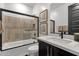 Modern bathroom featuring a tub/shower combo with sleek glass, tiled walls, and a modern vanity at 21632 W Hillcrest Blvd, Buckeye, AZ 85396