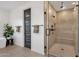 A gorgeous shower behind glass features a stone floor, tile walls, and a mounted shower head at 21632 W Hillcrest Blvd, Buckeye, AZ 85396