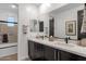 Bathroom featuring double sinks, modern faucets, a large mirror, and a tiled shower/tub at 21632 W Hillcrest Blvd, Buckeye, AZ 85396