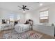 Bright bedroom with multiple windows, a desk, dresser, and a fun, colorful rug at 21632 W Hillcrest Blvd, Buckeye, AZ 85396