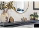 A decorated console table with flowers, mirror, bowl, and decorative accessories at 21632 W Hillcrest Blvd, Buckeye, AZ 85396